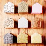 Close up Aligned Small Model Houses with Various insulation on Top of the Wooden Table